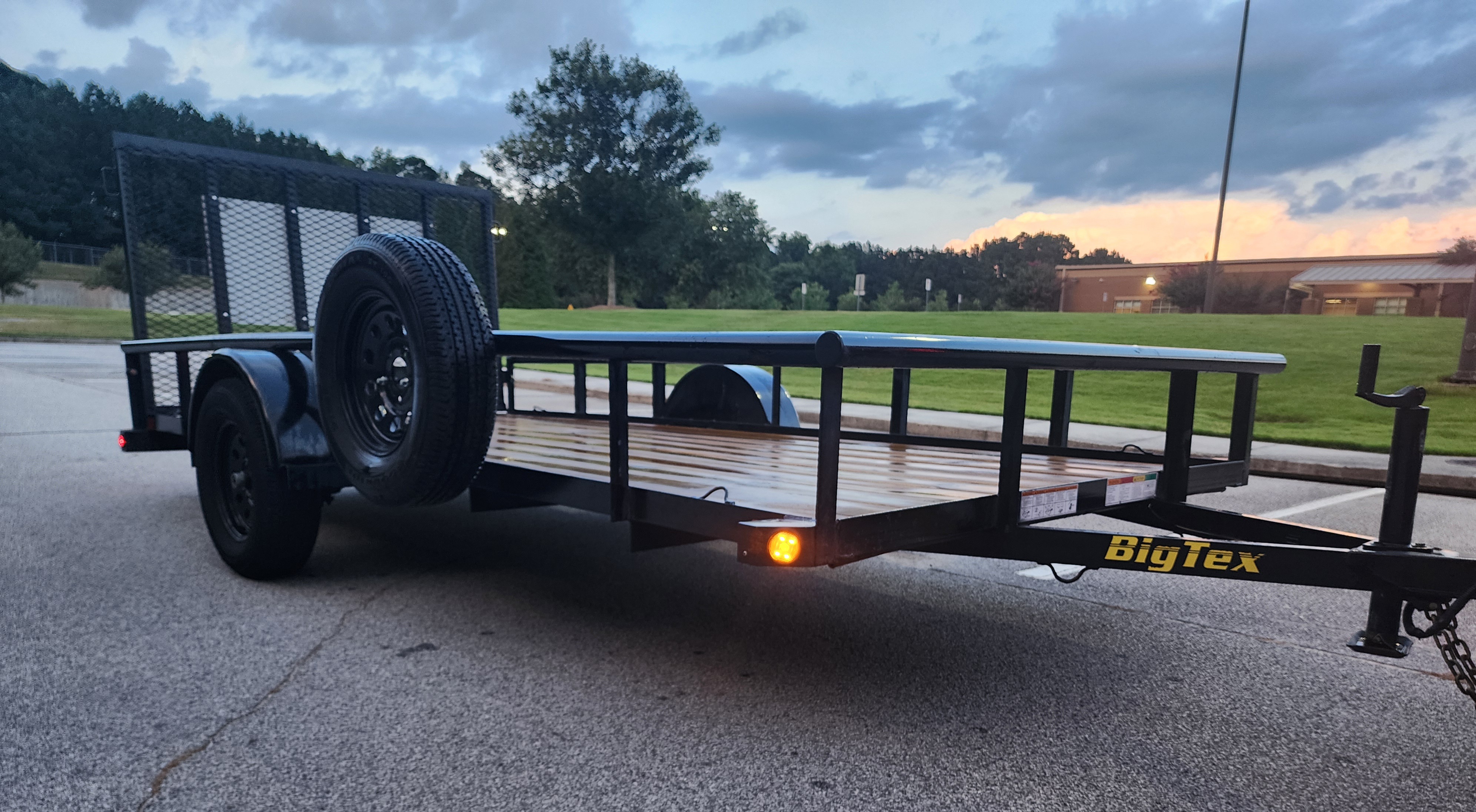 Empty Big Tex utility trailer with ramp gate at dusk