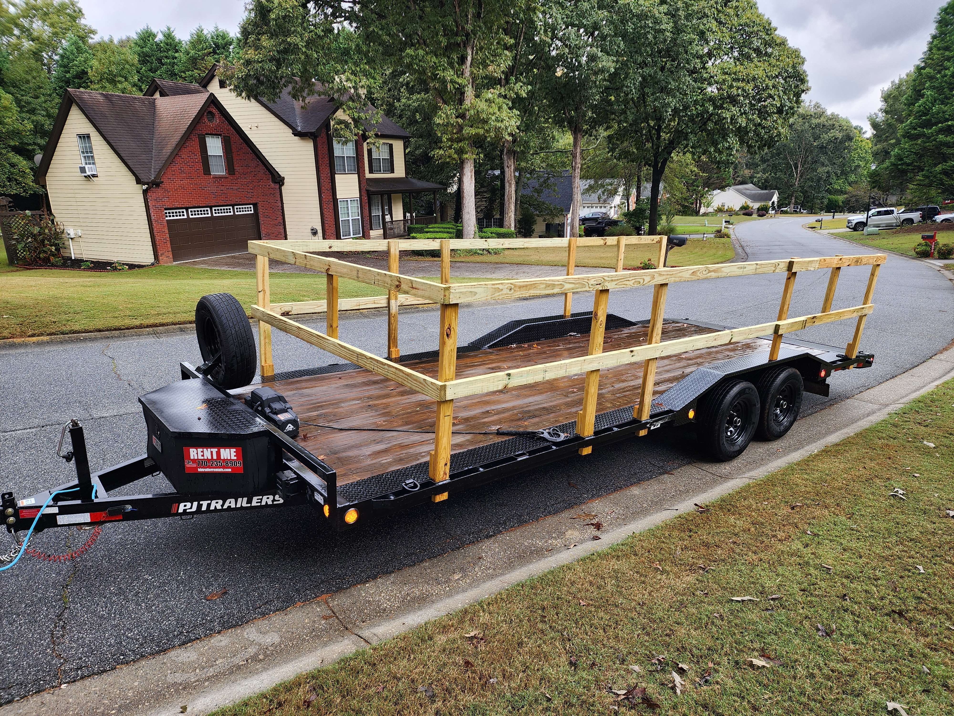 Utility trailer with wooden side rails ready for use in residential area