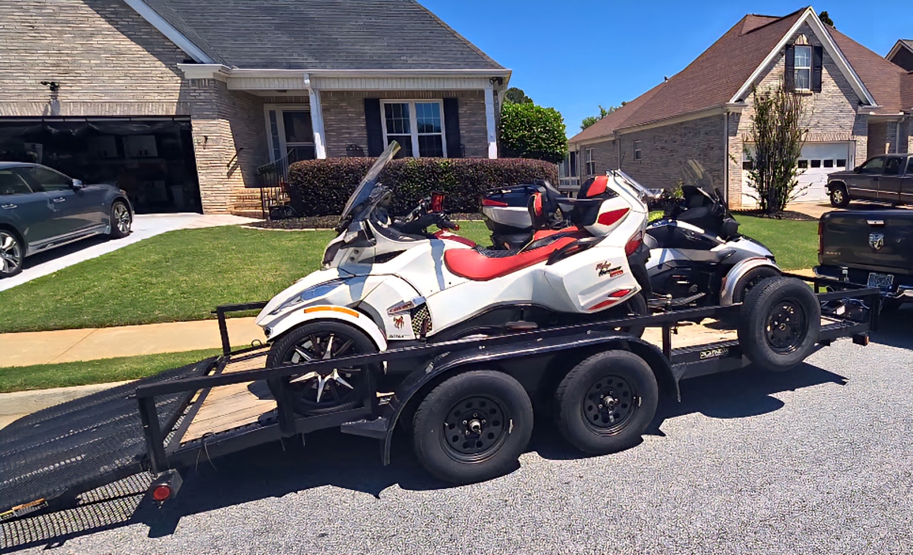 Utility trailer carrying a white and red Can-Am Spyder motorcycle