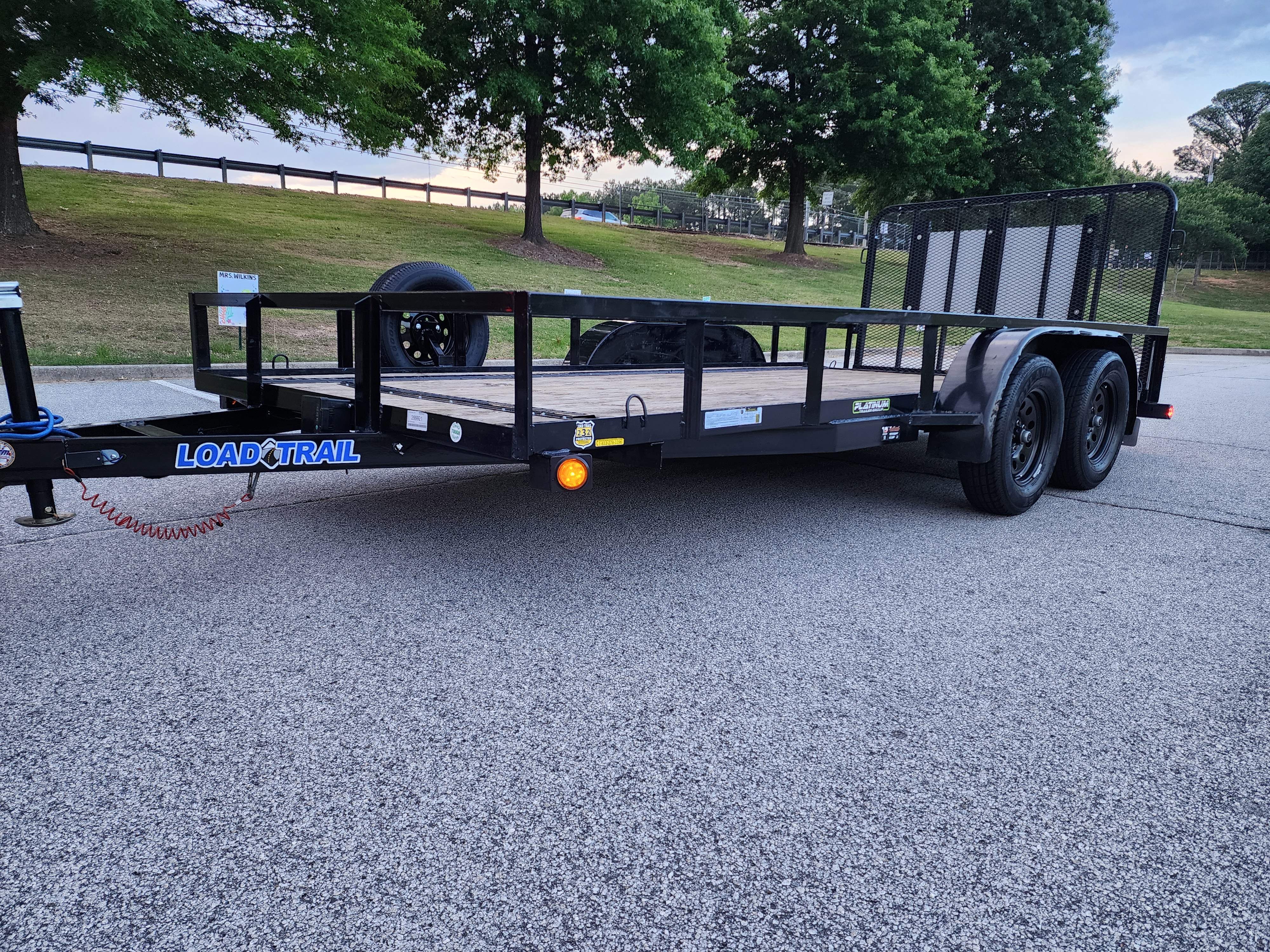 Side view of a black Load Trail utility trailer ready for rental