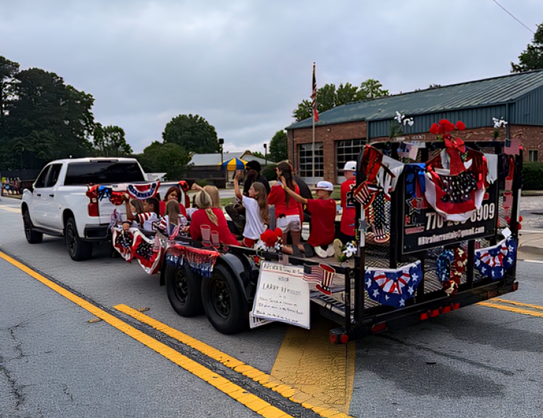 Howard Boys trailer decorated as a patriotic July 4th parade float carrying families