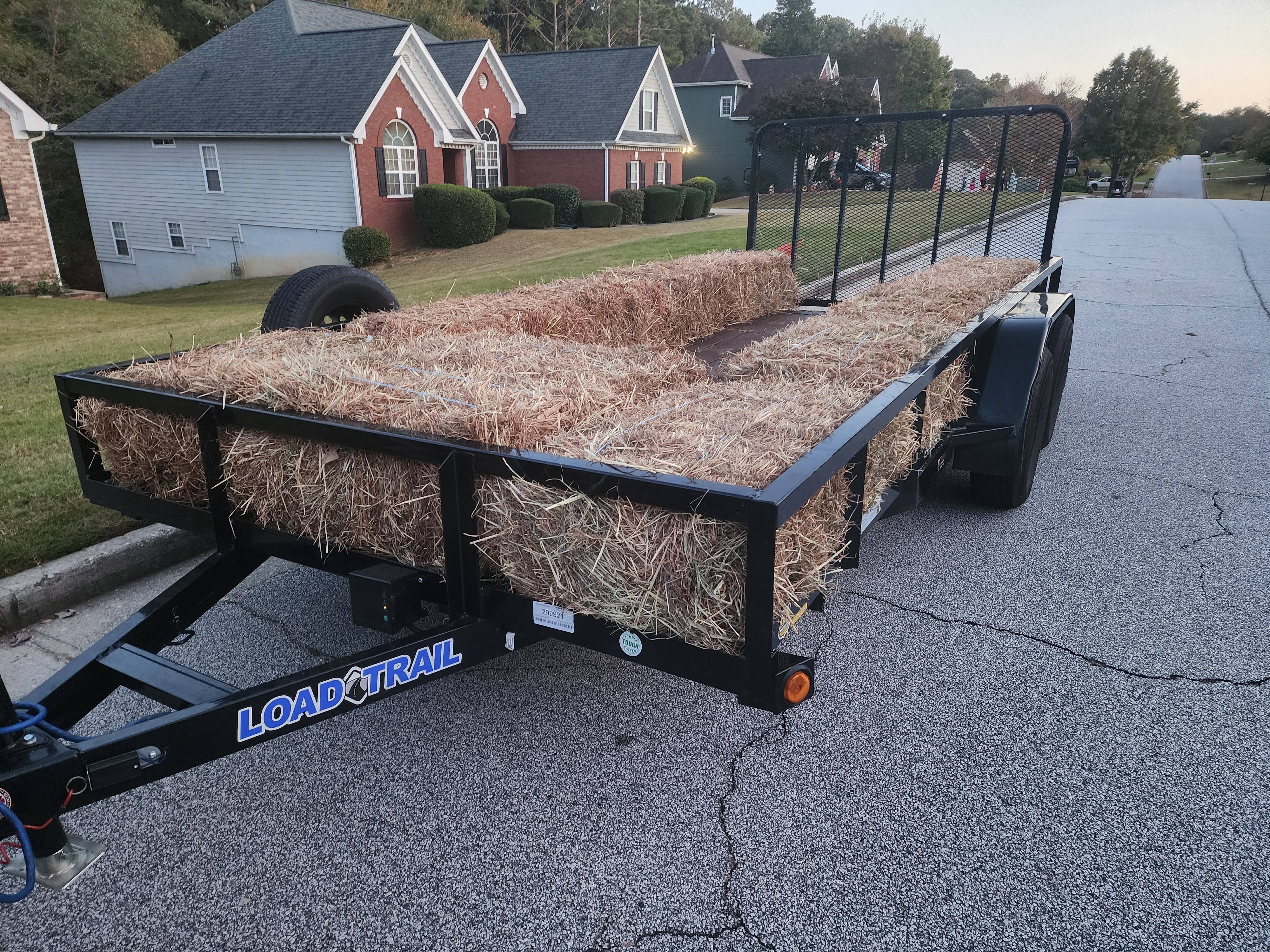 Utility trailer loaded with bales of hay
