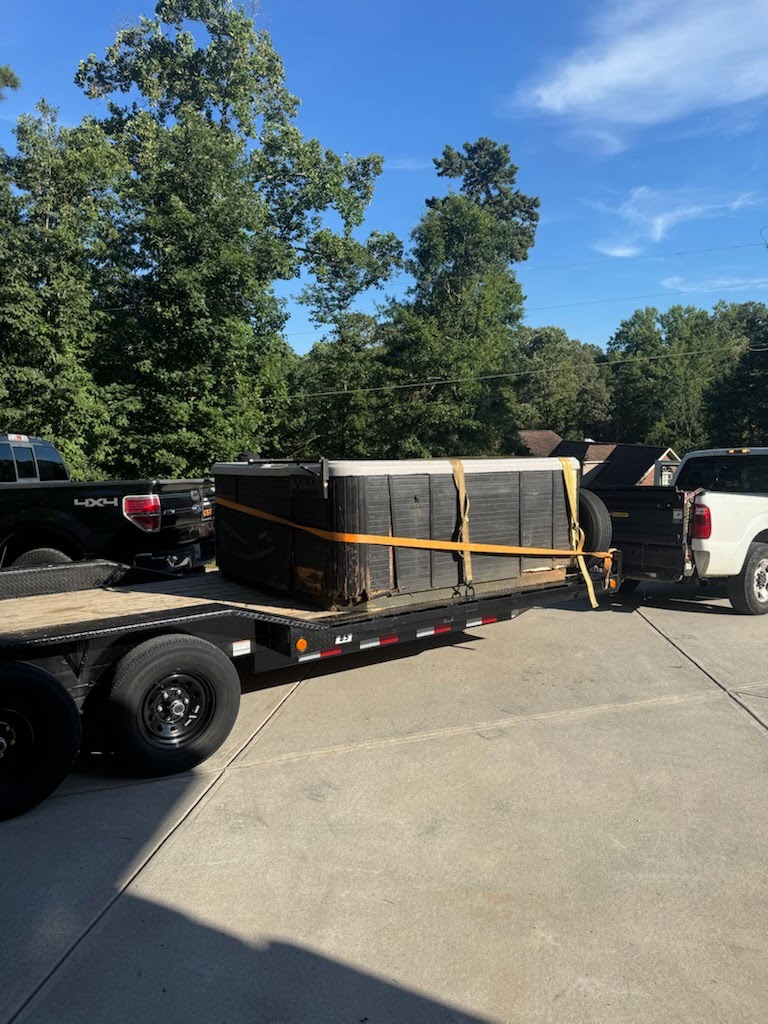 Flatbed trailer loaded with a large hot tub