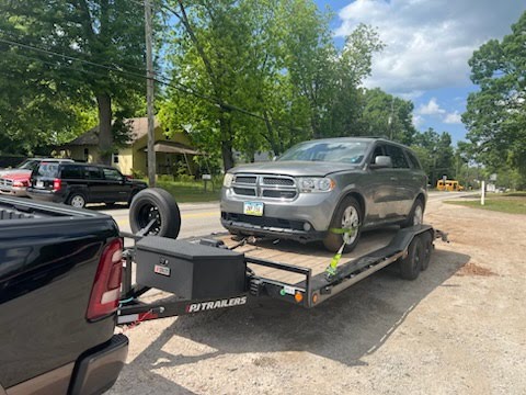 Utility trailer loaded with a grey Dodge Durango SUV