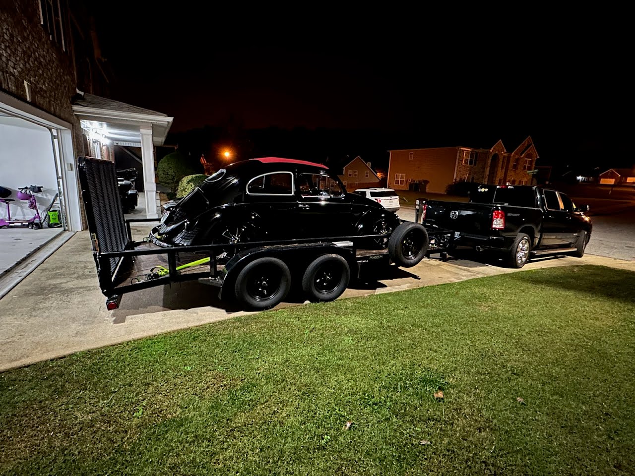 Utility trailer loaded with a black vintage car